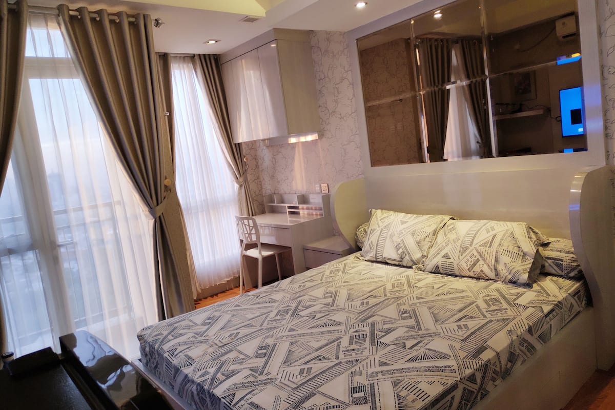 Une chambre à coucher moderne avec un lit, un bureau et une chaise.
