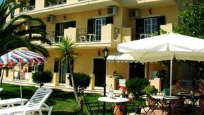 A multi-story building with balconies, outdoor seating, and a pool area. - Royal Rose (Corfu)