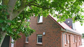 A brick building with multiple windows and a red roof. - Row end house in walking distance to the north city center for 4 people (Norden)