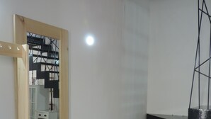 A modern interior with a staircase, a wooden door, and a tiled floor.