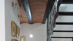 A modern interior with a staircase, tiled floor, and wall-mounted lighting fixtures.