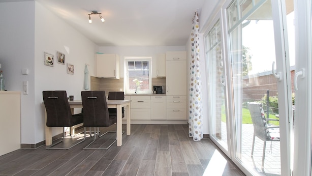 Una cocina moderna con comedor, ventanas amplias y vistas al exterior.