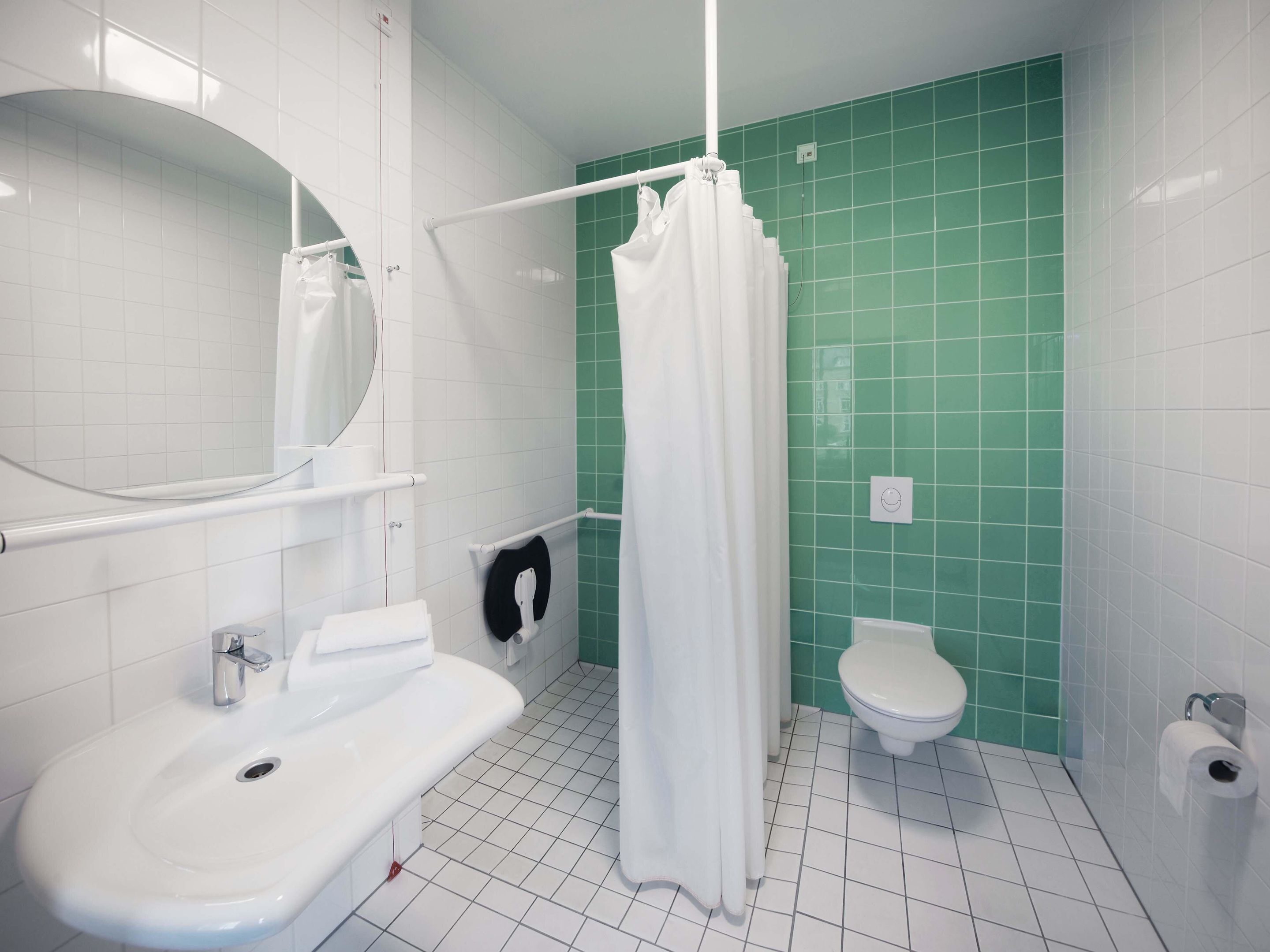 Un baño con un lavamanos blanco, un inodoro y una cortina de ducha.