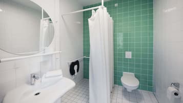 Un baño con un lavamanos blanco, un inodoro y una cortina de ducha.