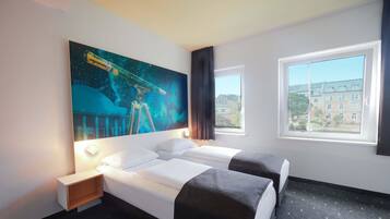 A hotel room with two beds, a large window, and a space-themed wall mural.