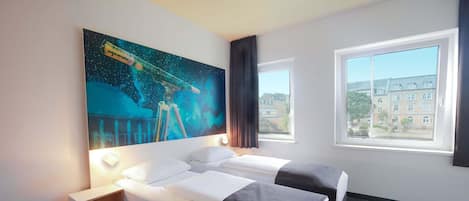 A hotel room with two beds, a large window, and a space-themed wall mural.