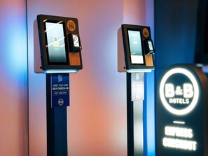 Deux bornes d’enregistrement automatique sont disponibles dans les hôtels B&B, avec un panneau indiquant « Départ rapide ».