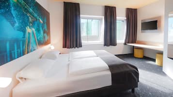 Ein Hotelzimmer mit einem großen Bett, einem Schreibtisch, einem Flachbildfernseher und einem Gemälde an der Wand.