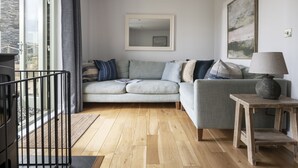 A modern living room with a grey sofa, a wooden coffee table, and a painting on the wall. - Chi An Treth - sleeps 6 guests  in 3 bedrooms (Bude)