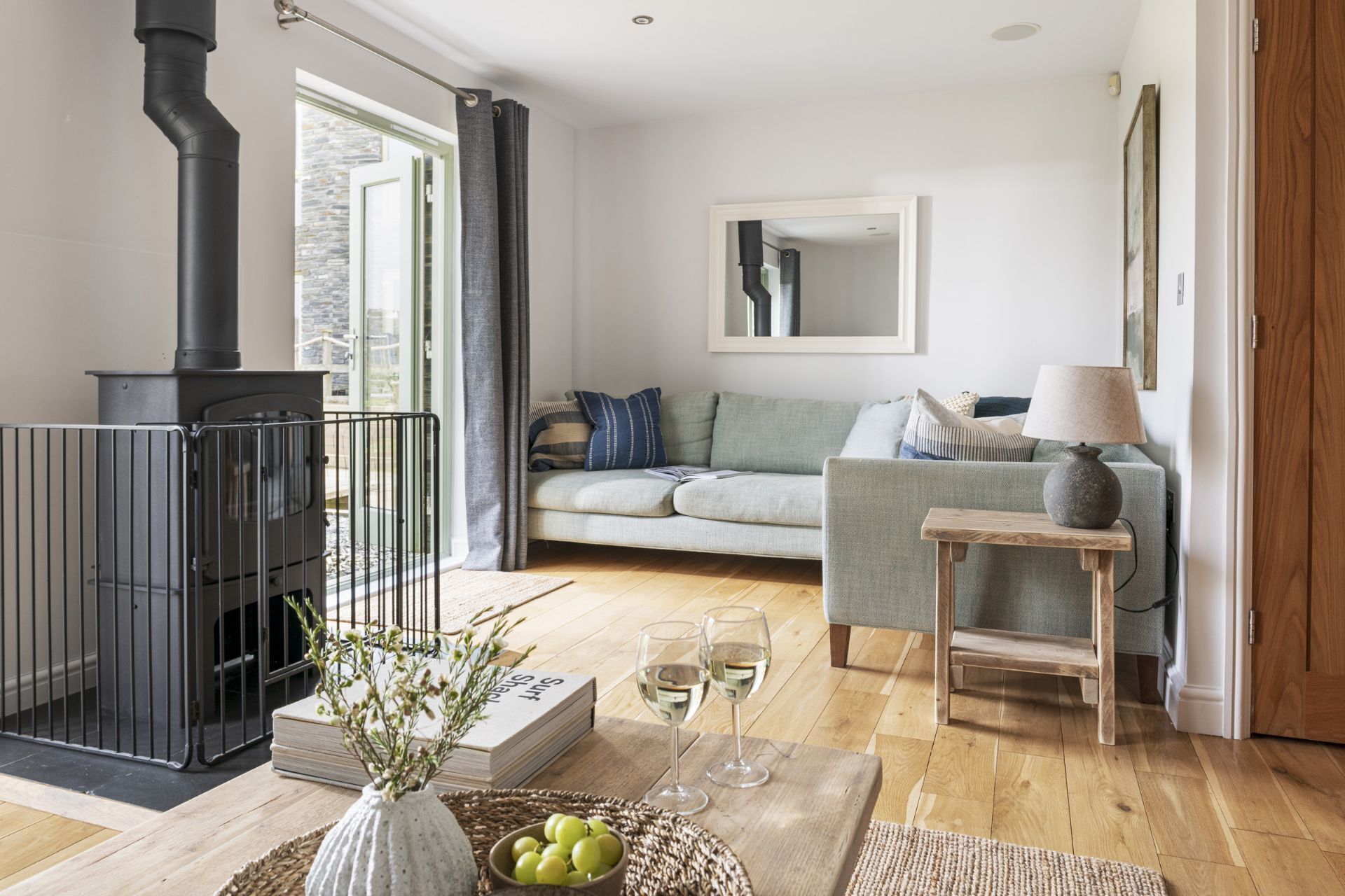 A cozy living room with a fireplace, a sofa, a coffee table, and a lamp.