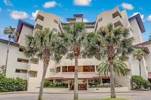 A multi-story hotel with a symmetrical facade, palm trees in front, and a red-tiled roof. - Sandcastle Retreat - Hosted by Moore AI Rentals (Fernandina Beach)