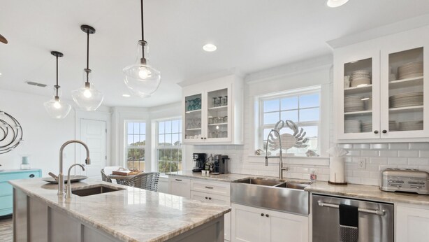 A modern kitchen with a central island, stainless steel appliances, and white cabinetry. - The Pelican`s Nest Egg - Hosted By Moore AI Rentals (Fernandina Beach)