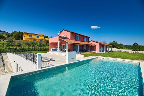 A large swimming pool with a house in the background.