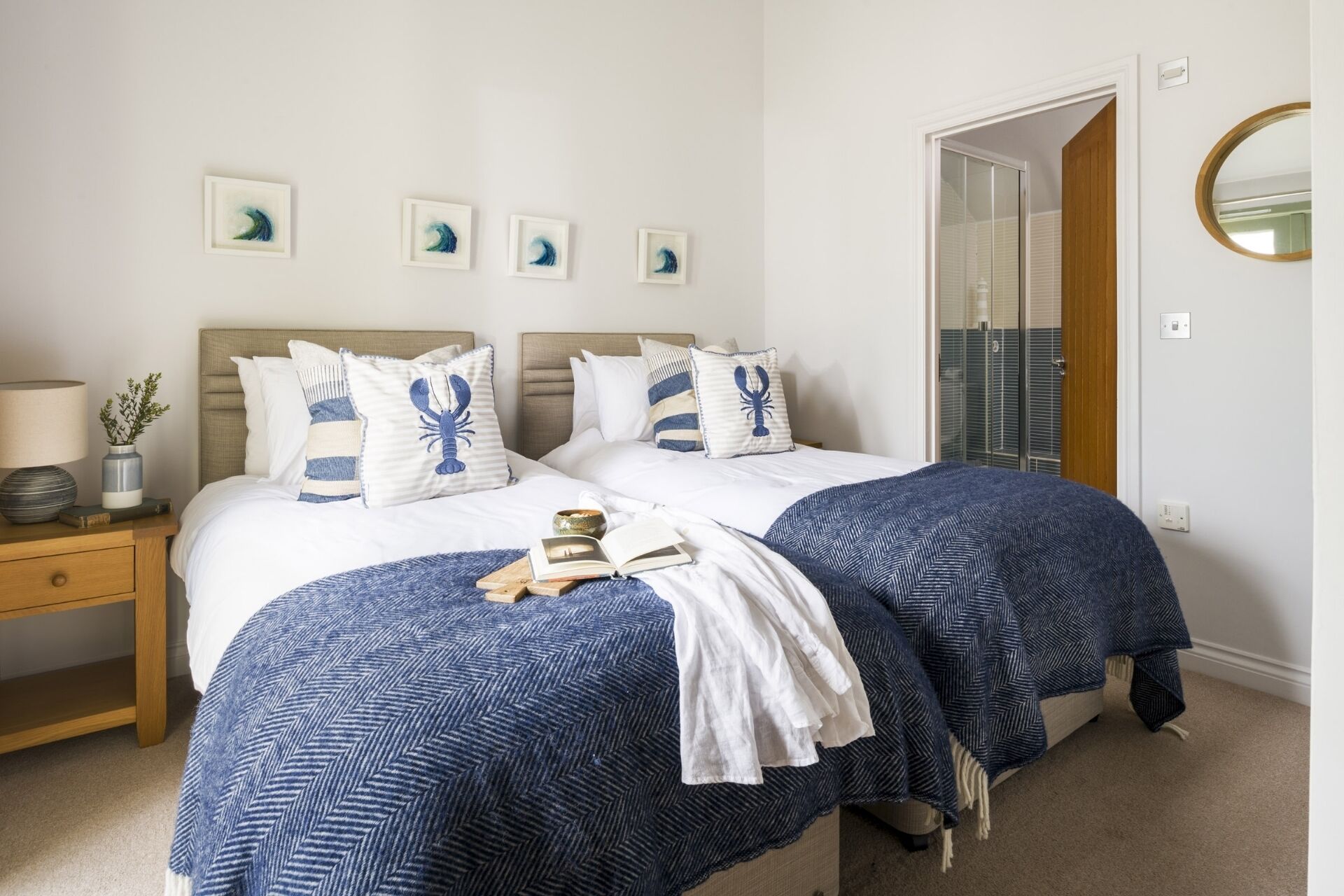 A double bed with a headboard, two bedside tables, a lamp, a mirror, and a door leading to a balcony.
