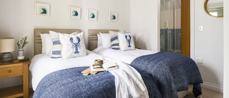 A double bed with a headboard, two bedside tables, a lamp, a mirror, and a door leading to a balcony.