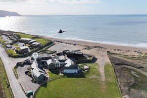 An aerial view of a coastal property with multiple buildings, a parking area, and a beach. - Chi An Mor - sleeps 6 guests  in 3 bedrooms (Bude)