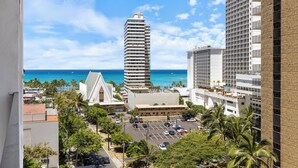 A high-rise hotel with a view of the ocean and palm trees. - Experience the Best, Waikiki Banyan with Free Parking & Wi-Fi! (Honolulu)