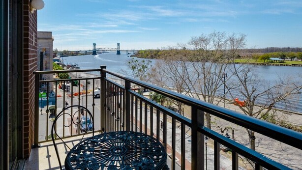 A balcony with a view of a river and a bridge. - DT~ Free parking~ Sunset river views~ WiFi~ W/D (Wilmington)