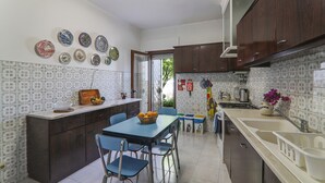 Une cuisine avec une table à manger, des chaises et diverses assiettes décoratives accrochées au mur.