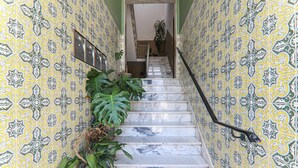 Un escalier dont les murs sont décorés de motifs et qui est muni d’une main courante.