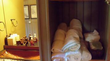 Guests can enjoy a convenient bathroom with a shelf for storing toiletries and towels.