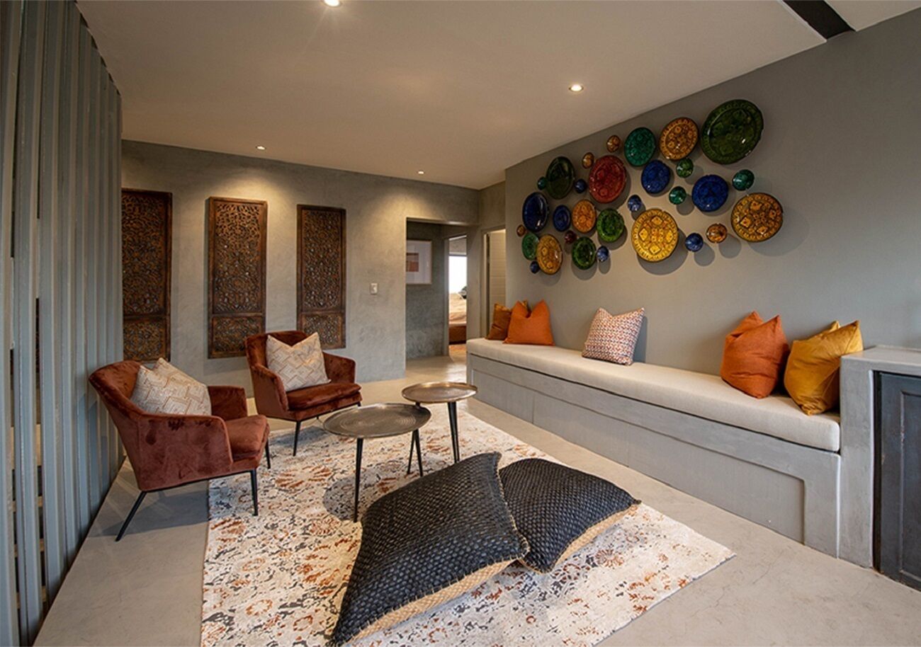 A modern living room with a sofa, two armchairs, a coffee table, and a patterned rug.