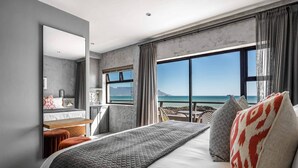 A modern hotel room with a large bed, a desk, and a view of the sea. - Belle Maroc (Cape Town)