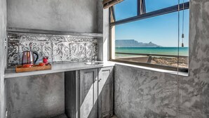 A kitchen with a view of a beach and mountains. - Belle Maroc (Cape Town)