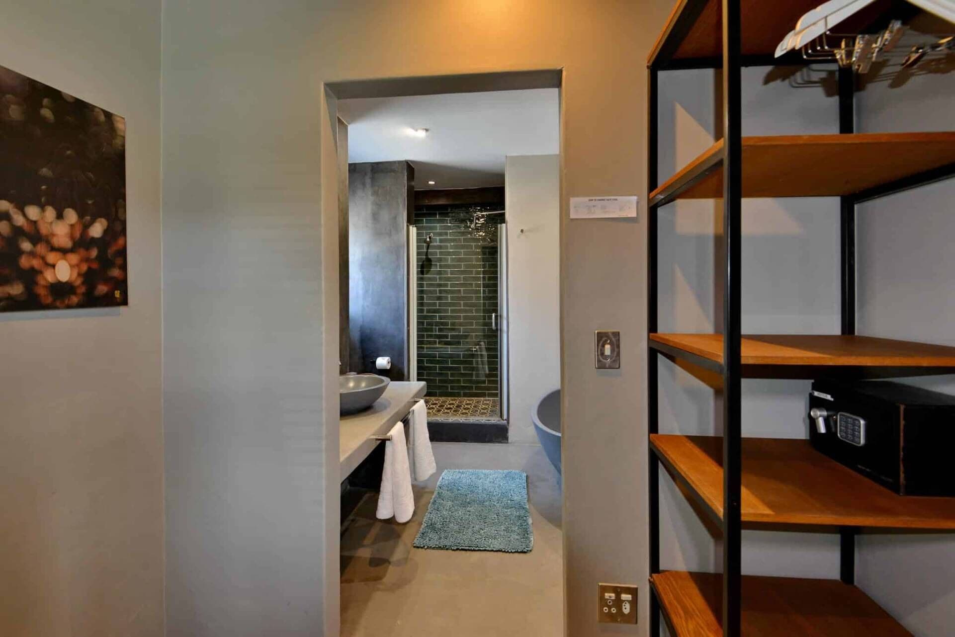 A modern bathroom with a glass shower, a sink, and a towel rack.