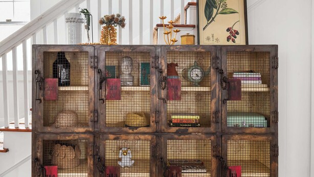 A staircase with a rustic wooden crate display containing various items like hats, books, and decorative objects. - Edgy Overlook (Atlanta)