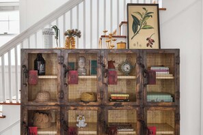 Una escalera con una exhibición rústica de cajas de madera que contienen varios objetos como sombreros, libros y adornos.