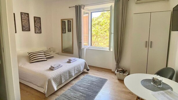 Una camera da letto con un letto, una scrivania, una sedia, una finestra e una lampada a soffitto.
