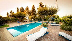 A rectangular swimming pool with a tiled deck, surrounded by lounge chairs and a small table. - Casa Lampedusa, for 2 people, with sea view, shared pool and access to the beach (Capo Vaticano Ricadi)