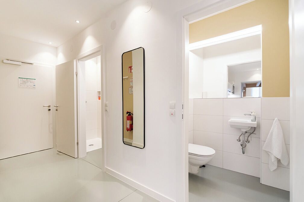 A modern bathroom with a toilet, sink, and mirror.