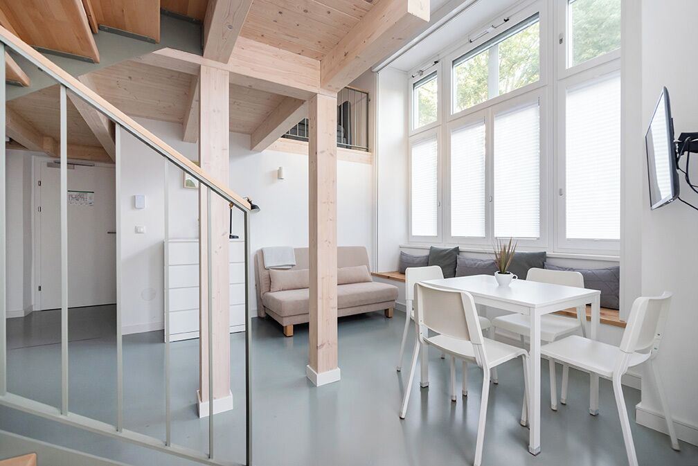Ein modernes Interieur mit Essbereich, einer Couch und einer Treppe.