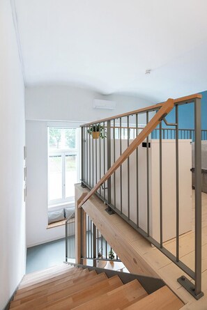 A staircase with wooden steps and metal railings leading to an upper floor.