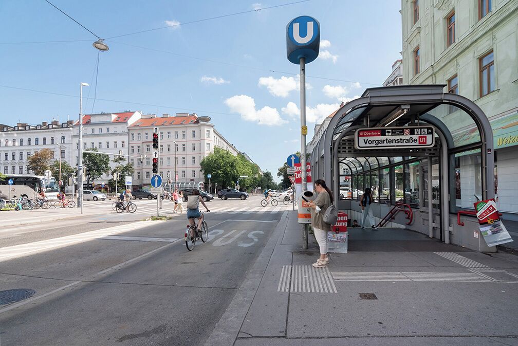 A bus stop with a shelter, a sign for 'Vorgartenstraße U1', and a tram line 'U1' overhead.