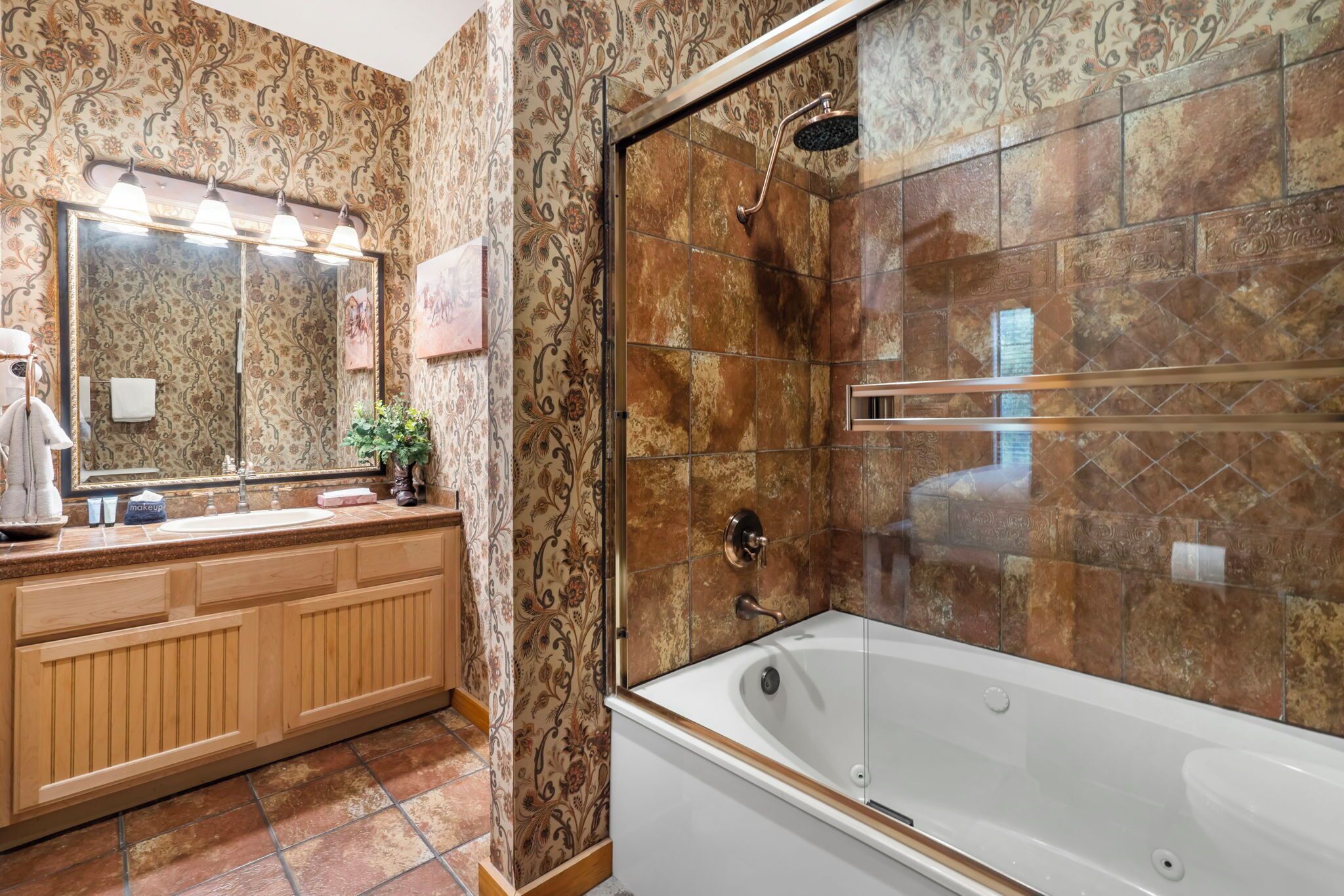 Ein Badezimmer mit einem großen Spiegel, einem Waschtisch und einer Badewanne mit Dusche.