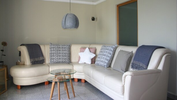 A living room with a beige sofa, a glass coffee table, and patterned throw pillows. - Quartier78 - Welcome to friends in Mittweida  (Mittweida)