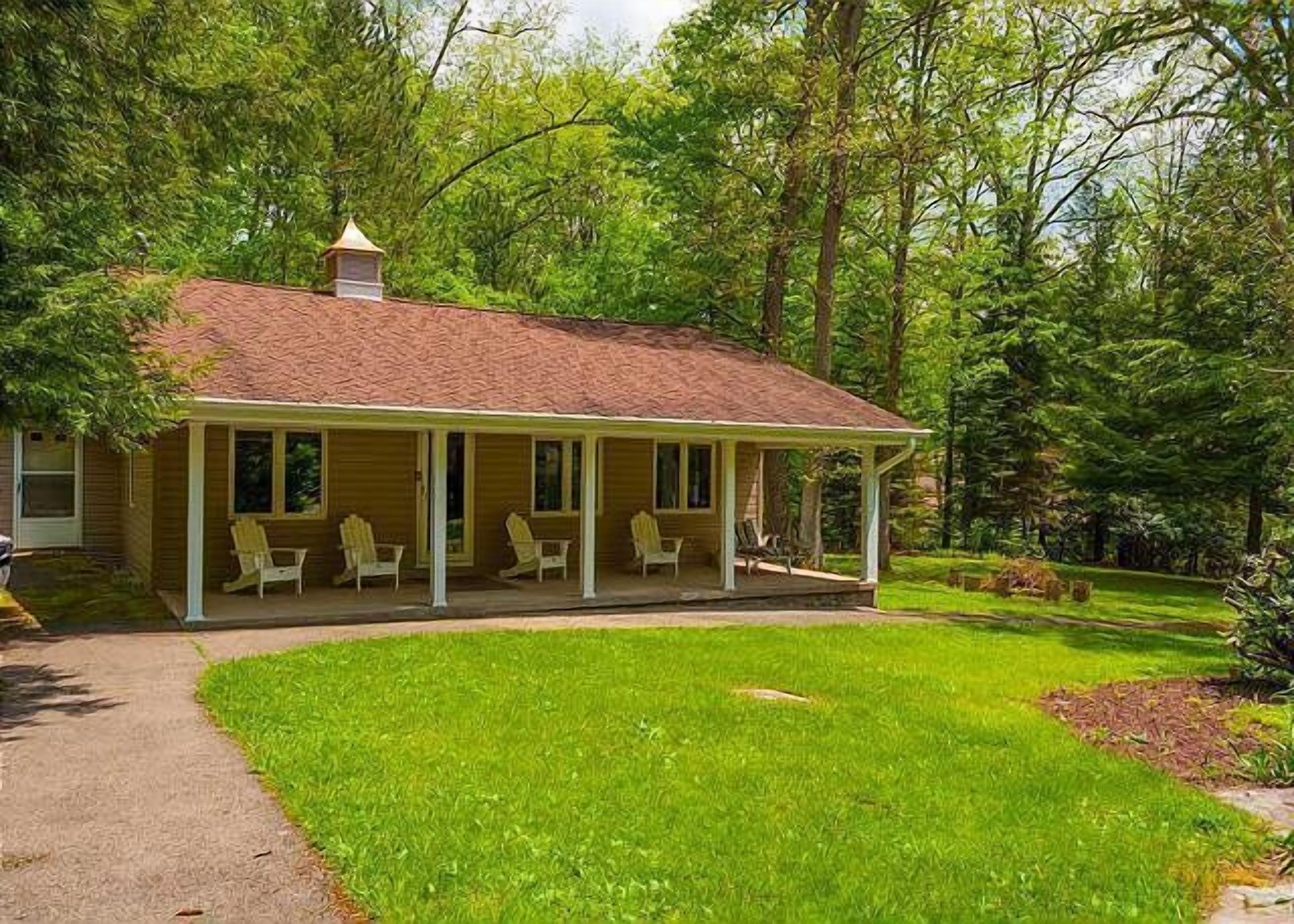 A single-story house with a porch and four chairs.