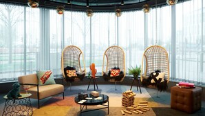 A modern living room with a sofa, coffee table, and hanging chairs. - Moxy Slough (Slough)