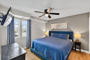 A bedroom with a bed, a ceiling fan, a desk, a window with curtains, and a wall-mounted map. - Close to Downtown, Modern 3 BR w/Driveway (Atlanta)