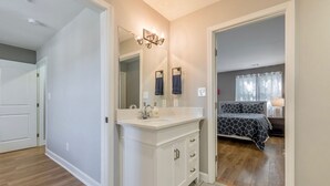 A modern bathroom with a white vanity, a large mirror, and a shower area.