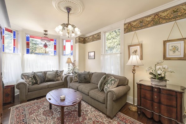 A living room with a sofa set, a coffee table, a lamp, and a decorative cabinet.