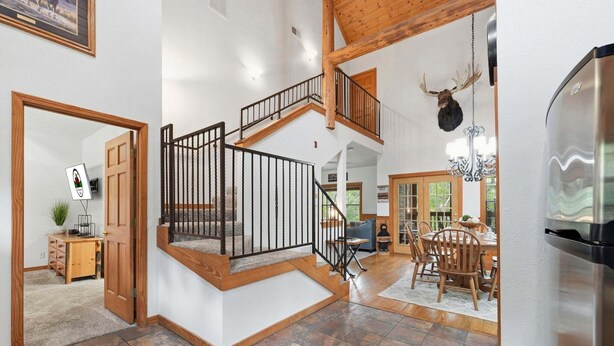 A spacious interior with a wooden staircase, a dining area, and a kitchen.