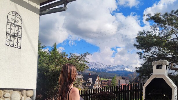 A person in a hot tub with a mountainous landscape in the background. - Apartament Na Wierchu (Poronin)