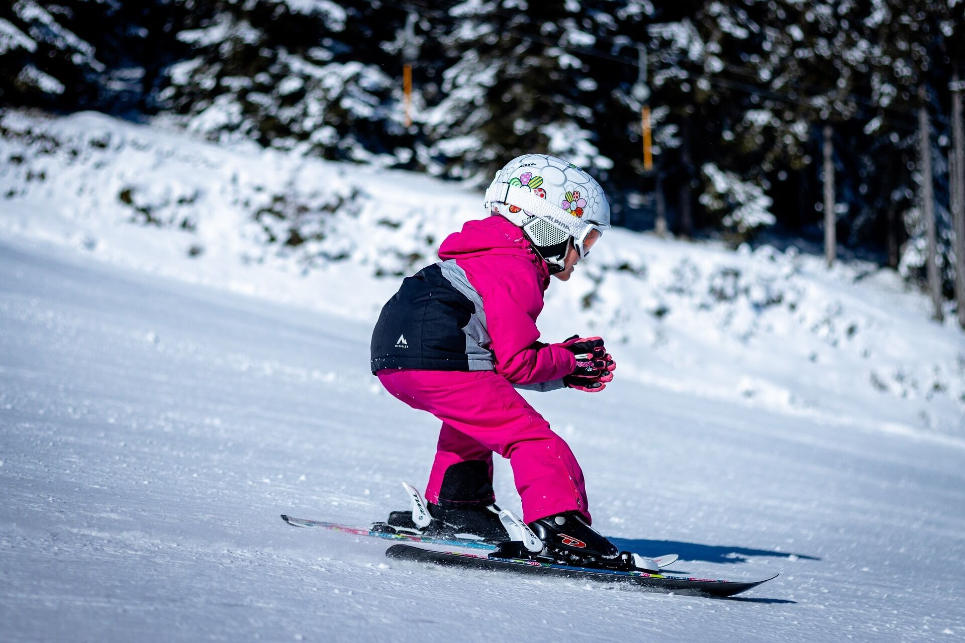 Uma snowboarder vestida de rosa em uma encosta nevada.