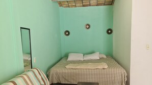 A small, cozy room with a bed, a striped sofa, and a small table. - Apartment with beautiful beach 3 blocks walking (Sayulita)