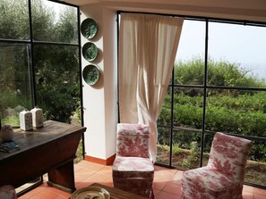 Enjoy a serene view of the lush landscape from the large window in this stylish room.