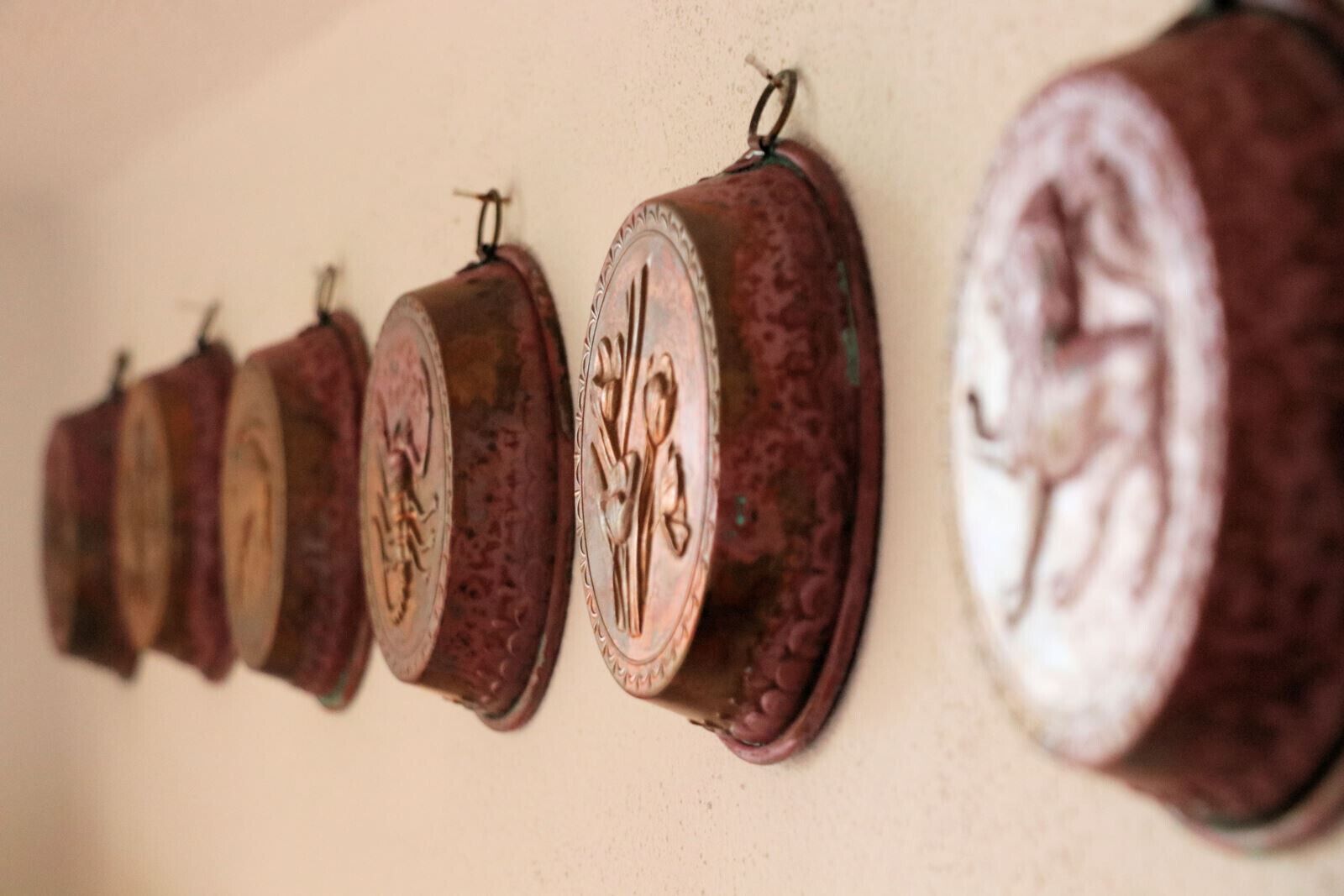 A row of wall-mounted objects with intricate designs.